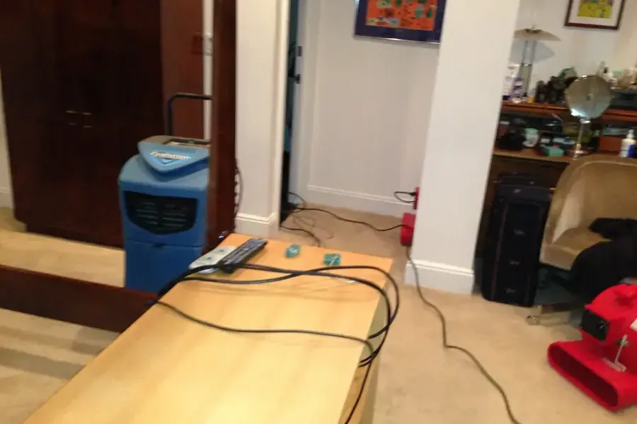 A dehumidifier and an air mover running in a room being dried after a water loss