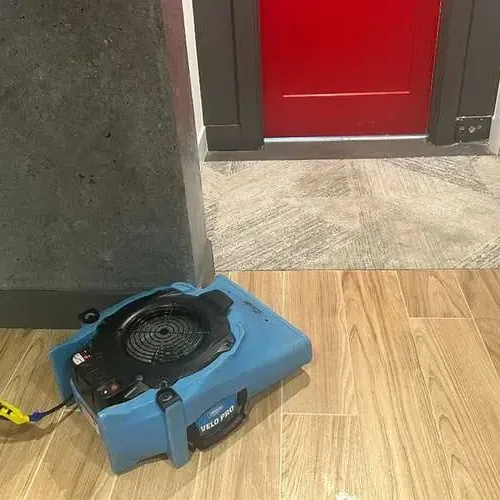 Chaska structural drying: an air mover on wood-look tile by a doorway
